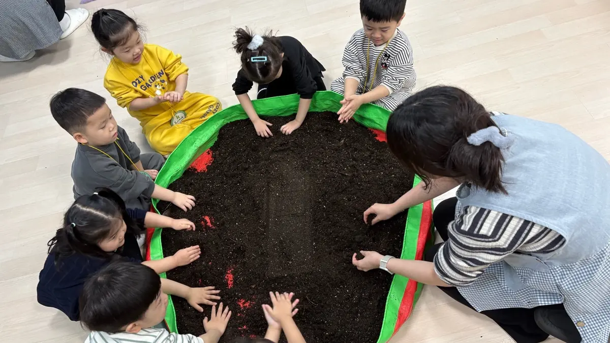 화단에 씨앗을 심는 아이들