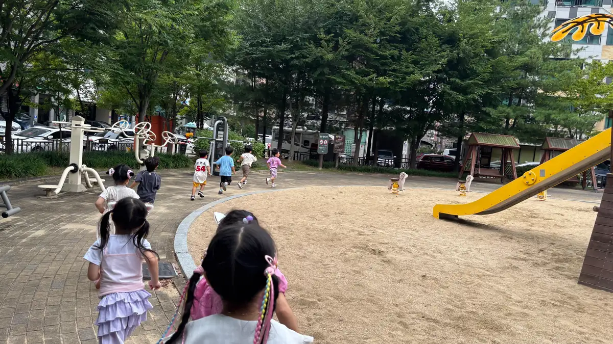 바깥놀이 시간에 놀이터 모래밭을 향해 달려가는 아이들