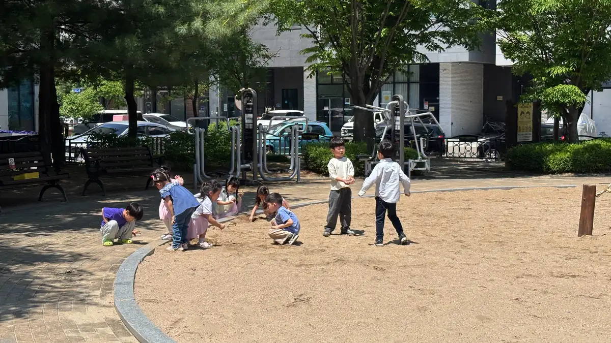 모래놀이터에 둘러앉아 노는 아이들